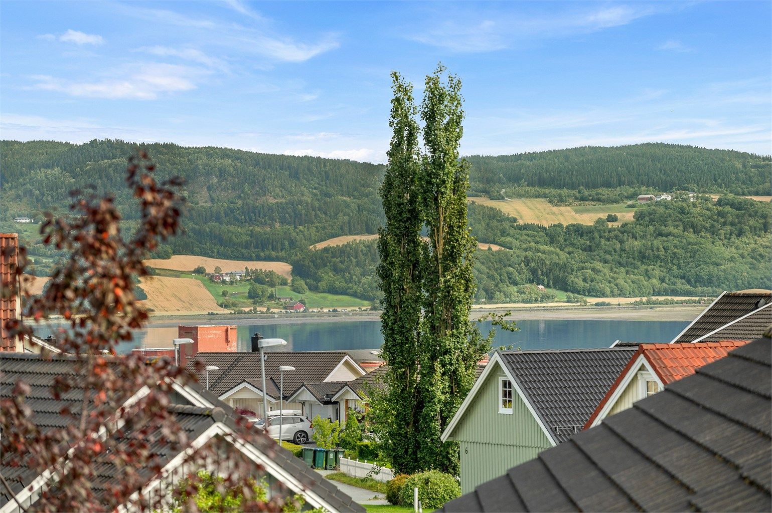 Flott utsikt i retning fjorden og det omkringliggende kulturlandskapet, med åser og grønne områder som en vakker ramme rundt nærområdet.
