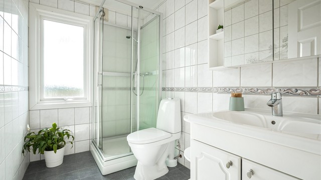 Lyst bad, av eldre dato. Badet har toalett (2026), dusjkabinett og gulvvarme.