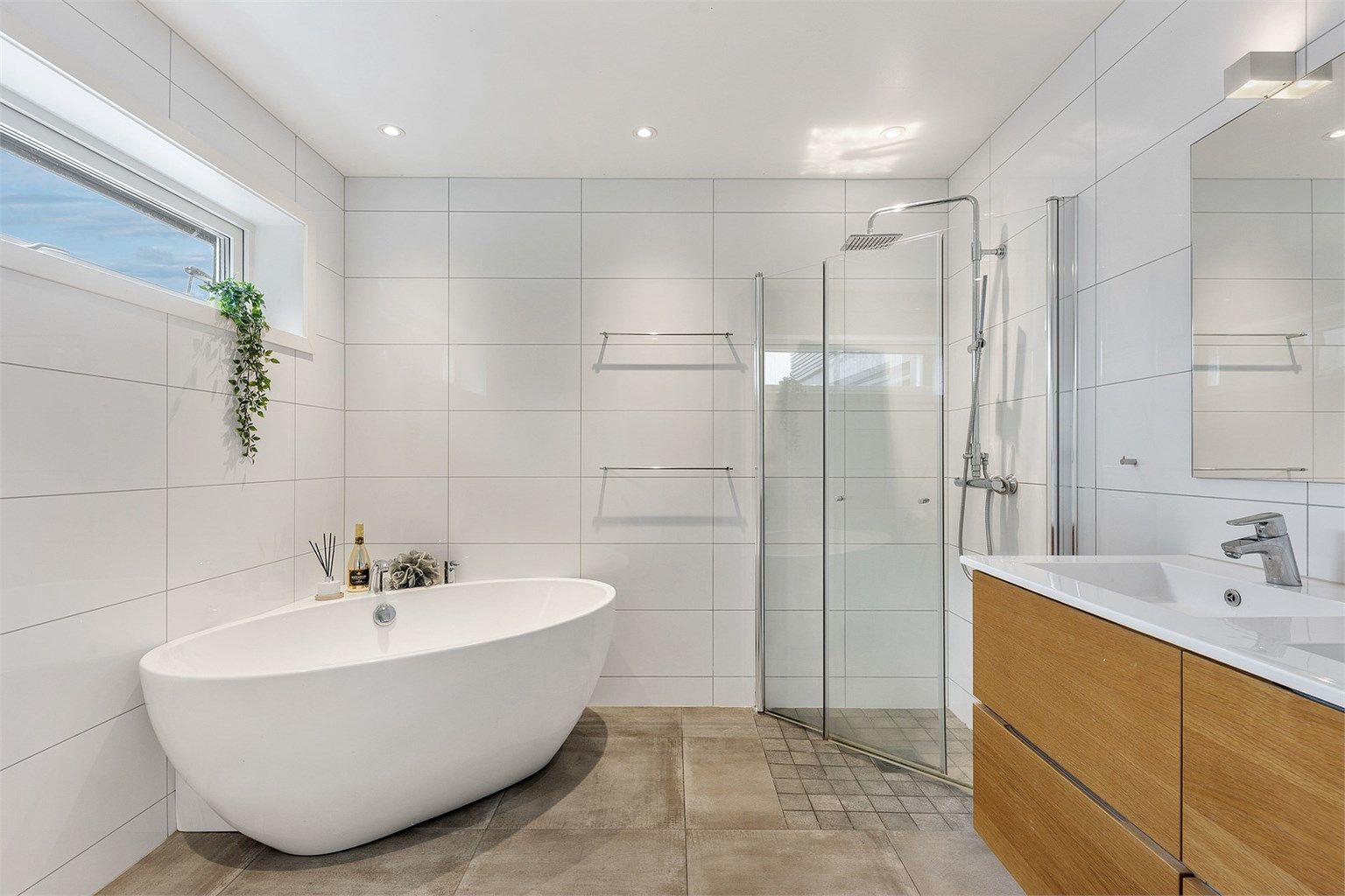 Hovedbadet i første etasje er flislagt og utstyrt med både dusjhjørne og et frittstående badekar.