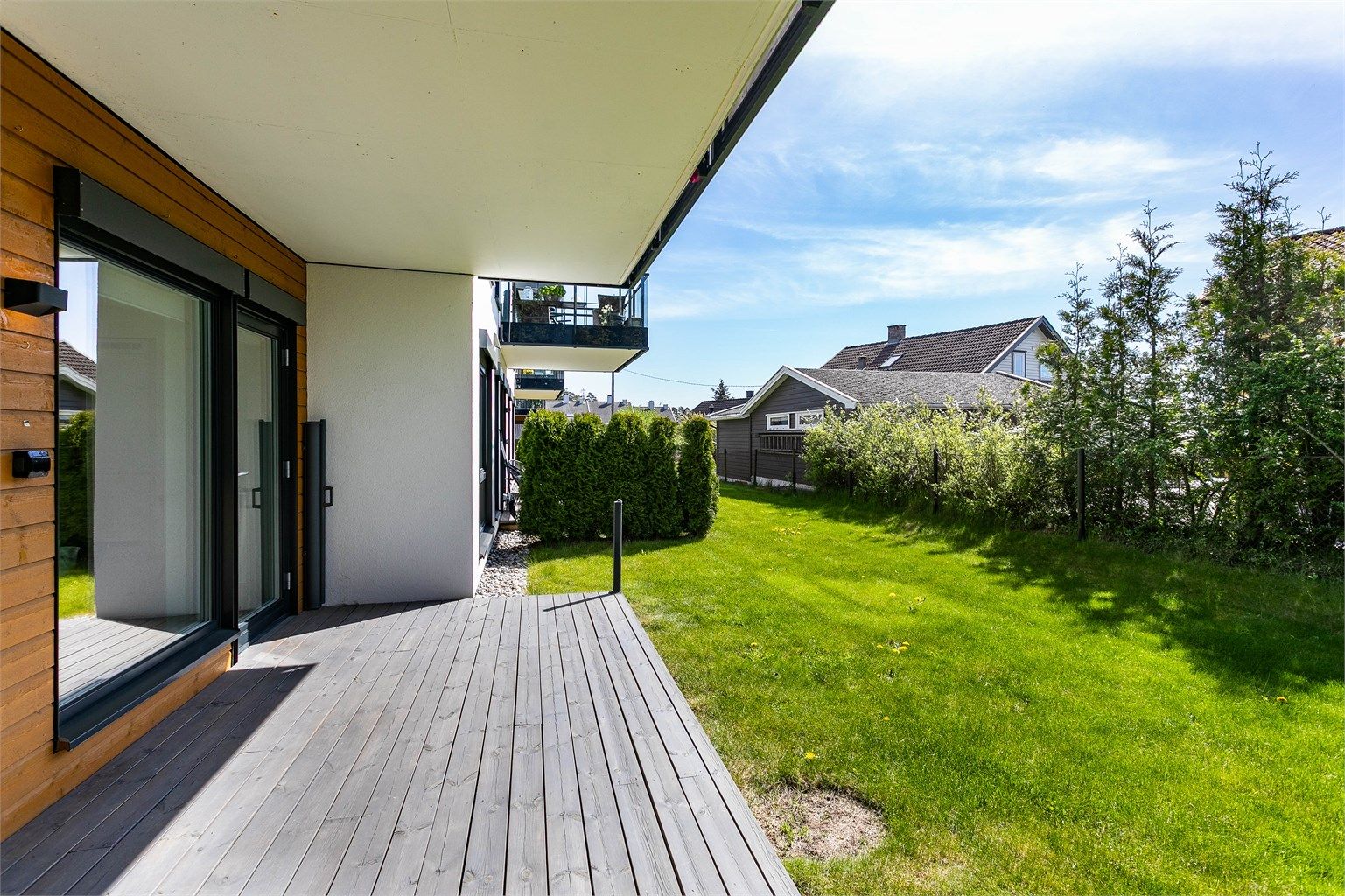 I årets varme måneder er plattingen solfylt dagen gjennom. Over stuevinduene er kasser montert som forberedelse for eventuelle screens.