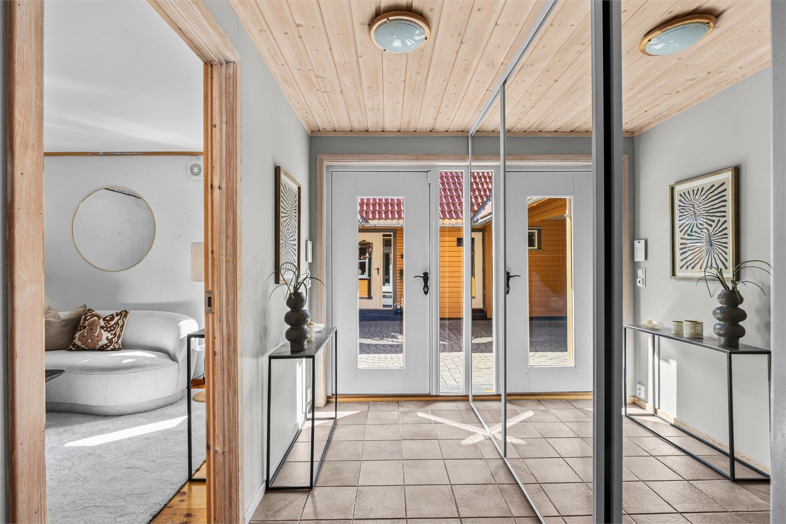 Romslig entré med stor skyvedørsgarderobe for oppbevaring av yttertøy. 