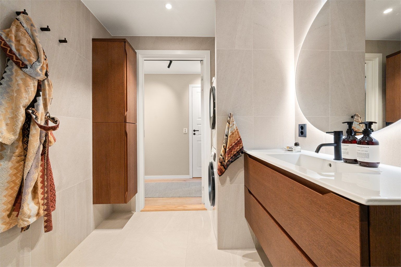 Rommet har tidløse fliser, elektrisk gulvvarme og et praktisk, vegghengt høyskap for ekstra oppbevaring.