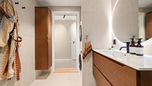 Rommet har tidløse fliser, elektrisk gulvvarme og et praktisk, vegghengt høyskap for ekstra oppbevaring.