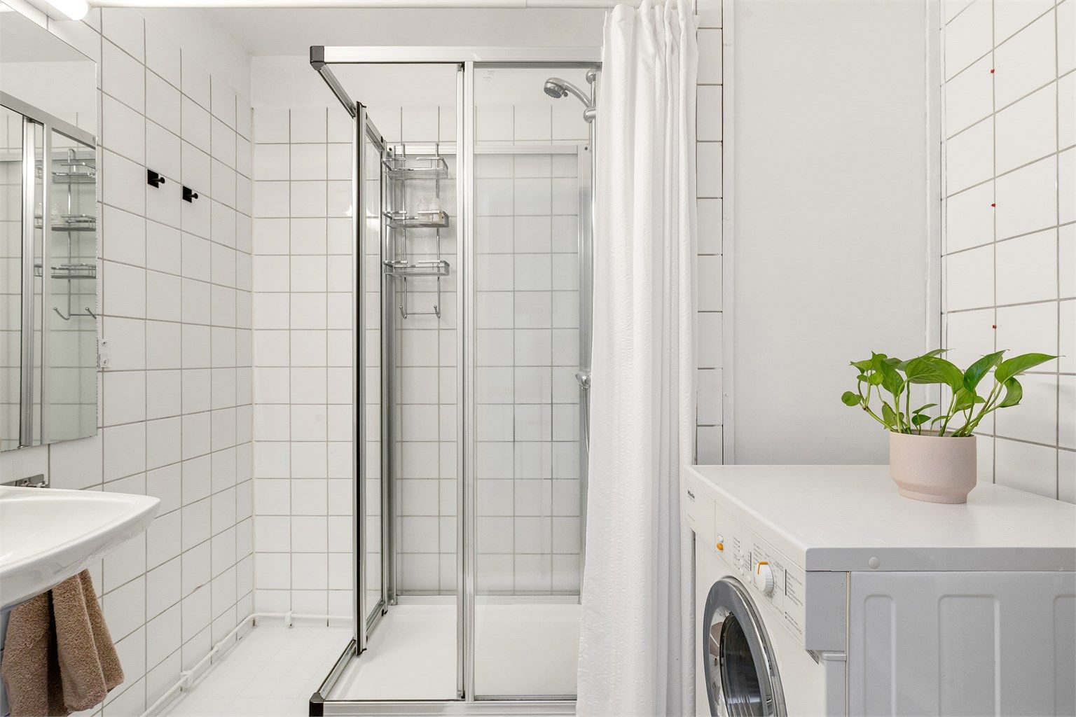 Badet er utstyrt med dusjkabinetg samt servant med overskap med speildører.