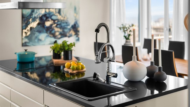 Kjøkkenøyen fungerer som et naturlig samlingspunkt, og den åpne løsningen gir en sosial og praktisk ramme rundt matlagingen.