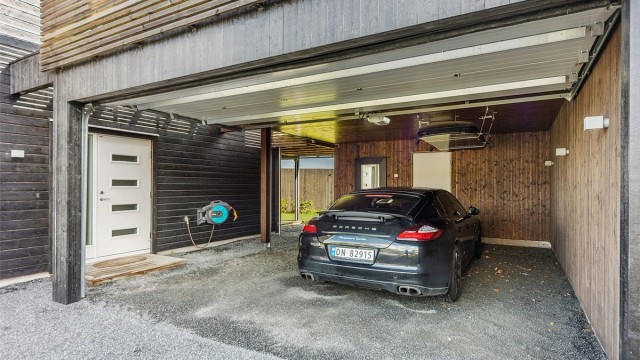 Boligen har en dobbel garasje/carport-løsning med sportsbod i bakkant.
