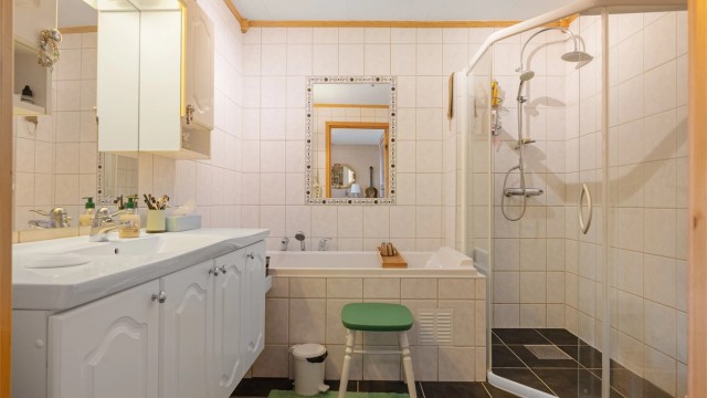 Pent flislagt bad på 6 kvm med gulvvarme og servantskap med overskap og speil med lys, vegghengt toalett, dusjhjørne med regndusj samt badekar.