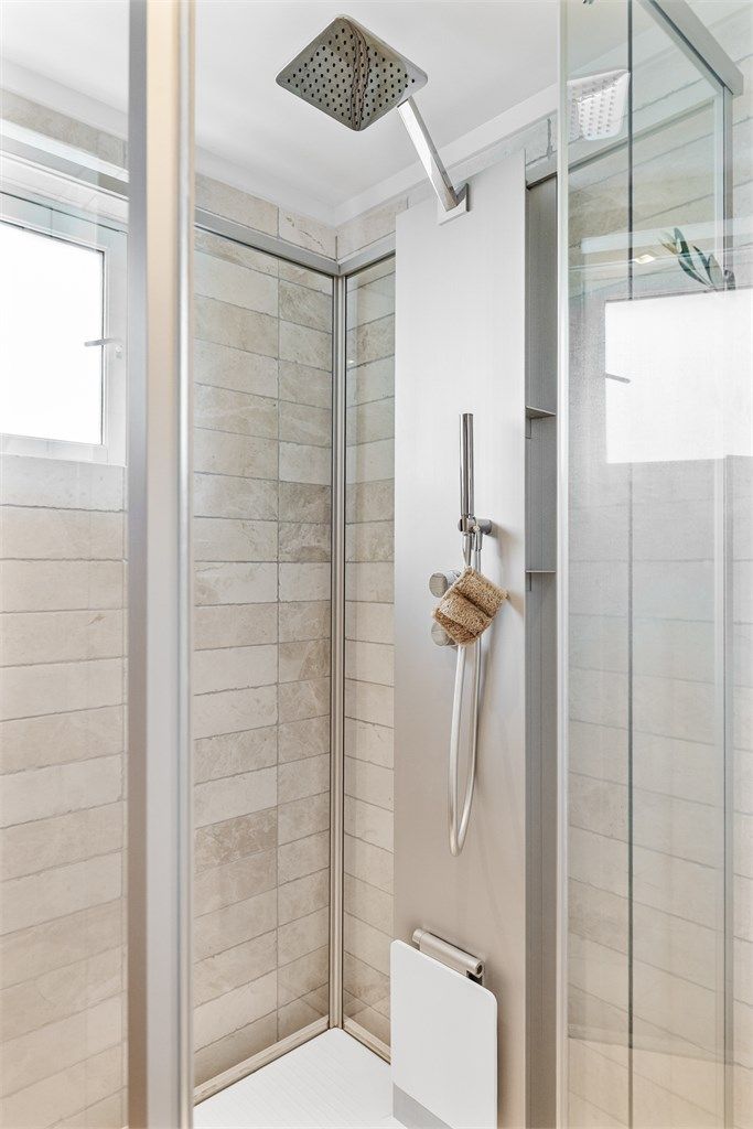 Videre har baderommet et romslig dusjkabinett med dusjsett og rainshower