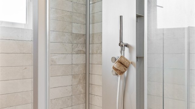 Videre har baderommet et romslig dusjkabinett med dusjsett og rainshower