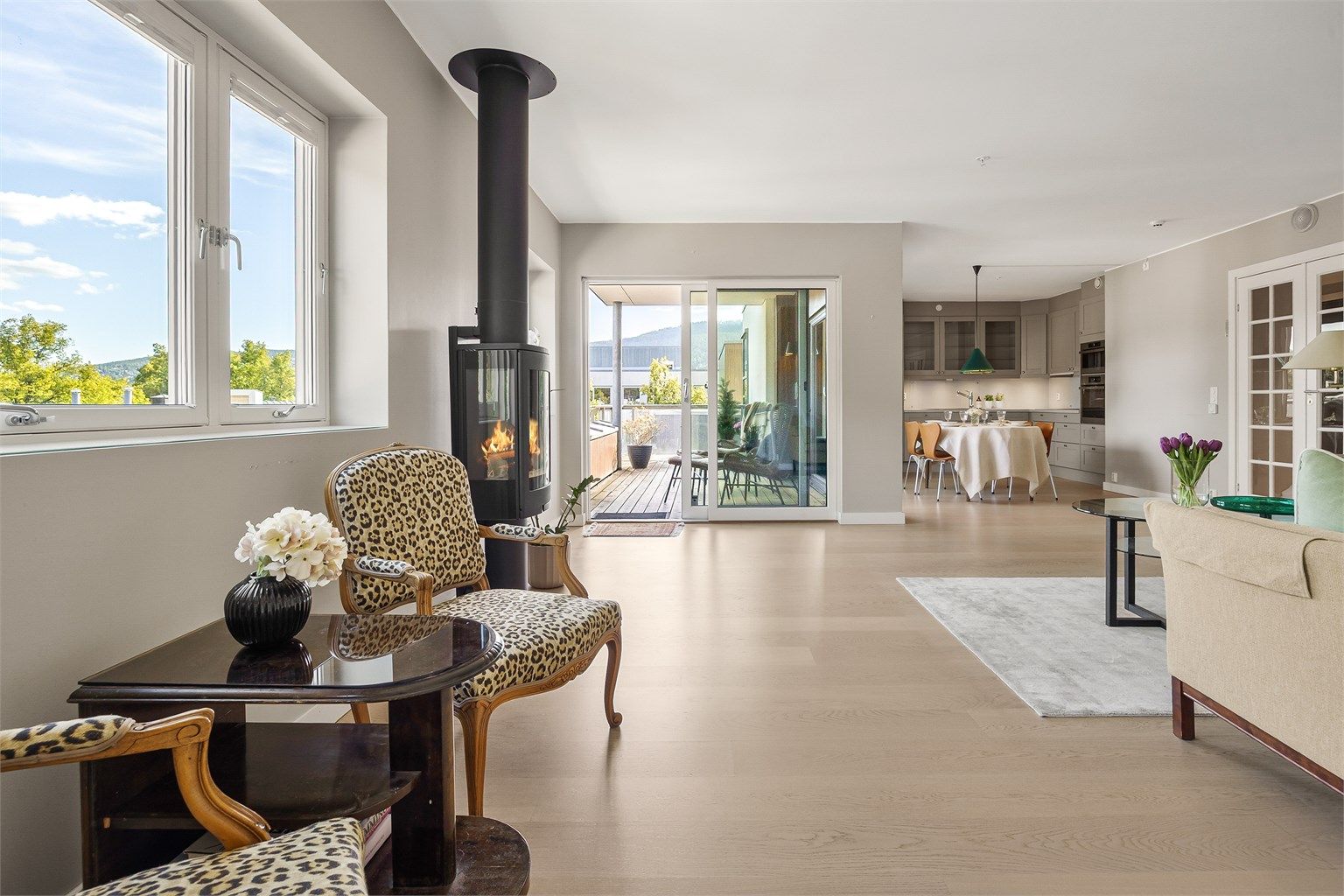 Lys og lun stue med sofaområde, sittegruppe samt spiseplass.