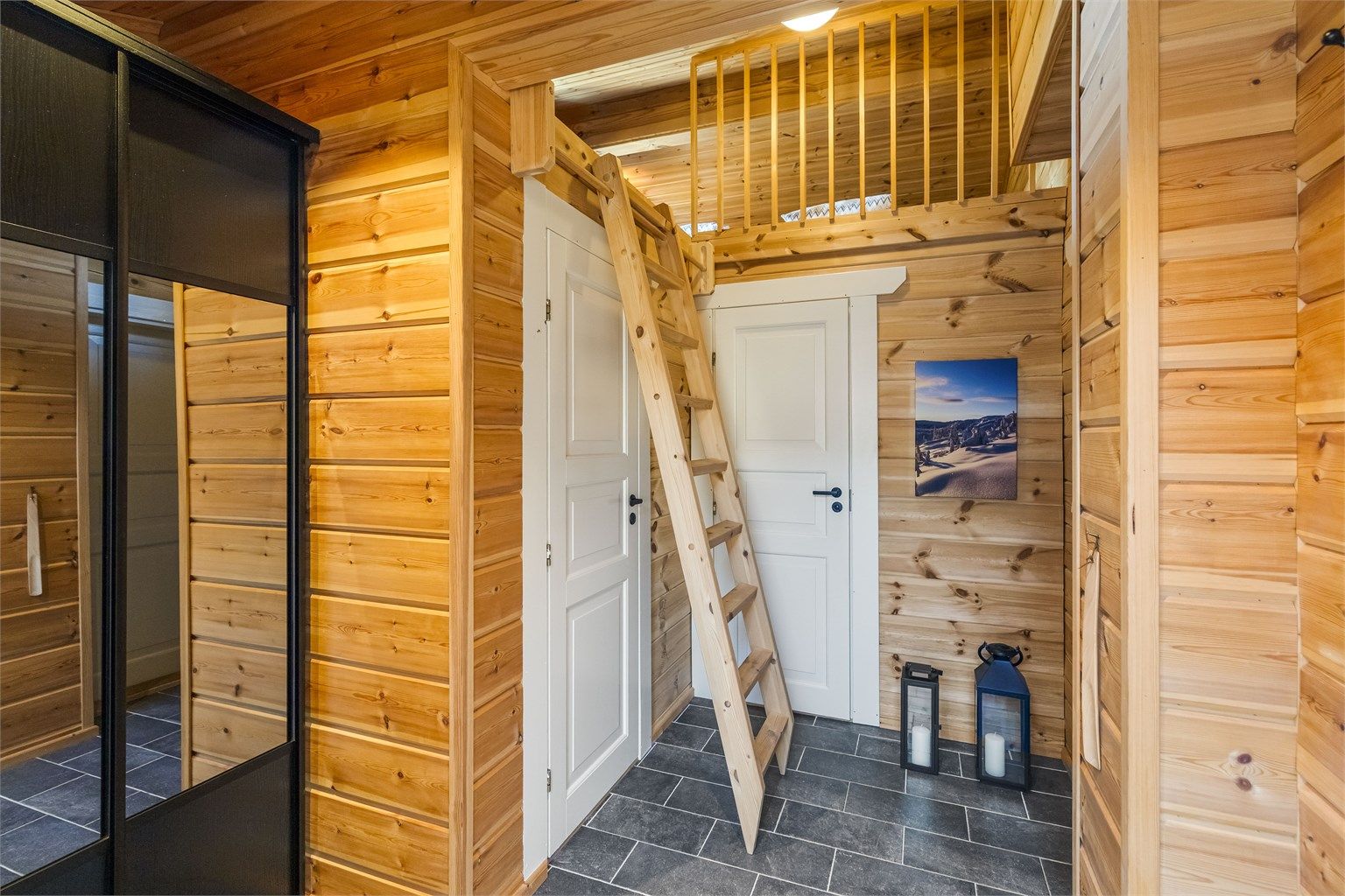 Entréen har flislagt gulv med gulvvarme og en romslig skyvedørsgarderobe for yttertøy. Stigen til hemsen er fleksibel og settes enkelt opp for bruk.