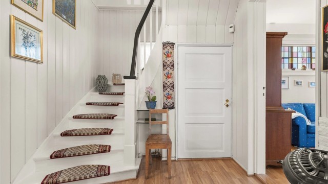 Fra gangen leder en klassisk tretrapp opp til andre etasje og ned til kjelleren.