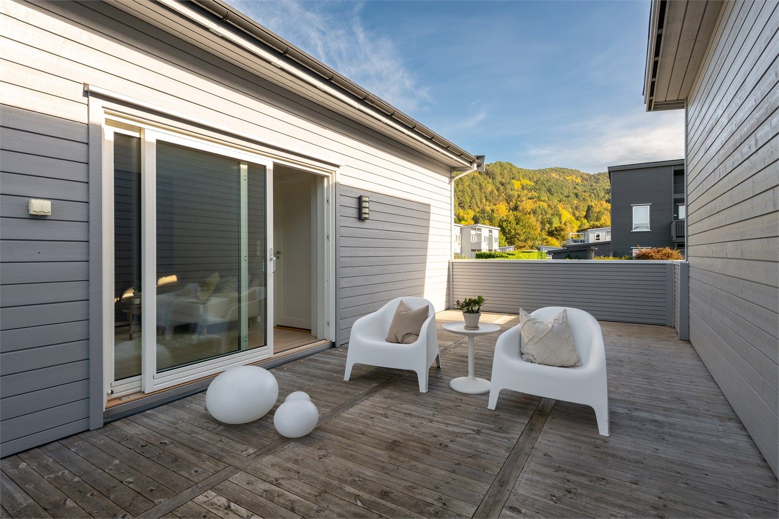 Verandaen har skjermende levegg og skyvedør i glass inn til loftstuen.