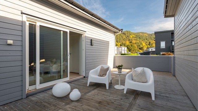Verandaen har skjermende levegg og skyvedør i glass inn til loftstuen.