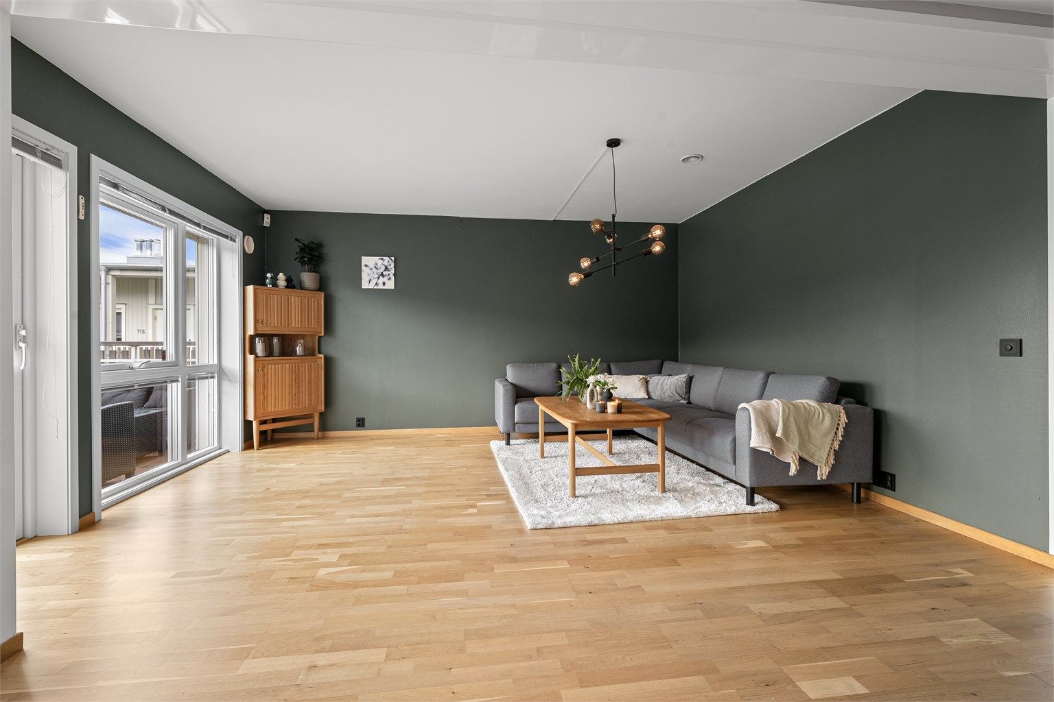 Stuen har god plass til en romslig sofagruppe og er et naturlig samlingspunkt i boligen.