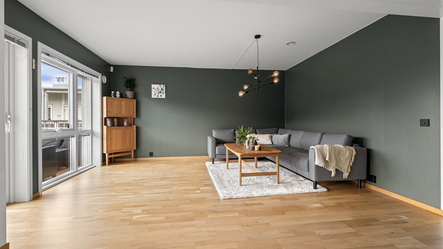 Stuen har god plass til en romslig sofagruppe og er et naturlig samlingspunkt i boligen.