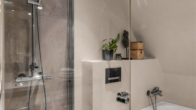 Dusjhjørne med glassdører. Dusjarmatur tilkoblet hånddusj og regndusj.