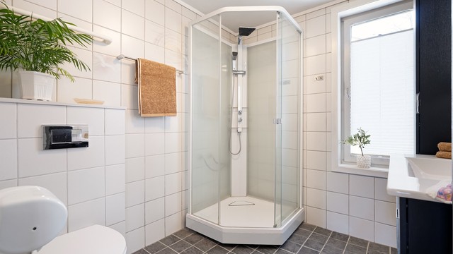Badet er innredet med vegghengt servantinnredning og ovenpåliggende servant med armatur, samt speil med sidelys.