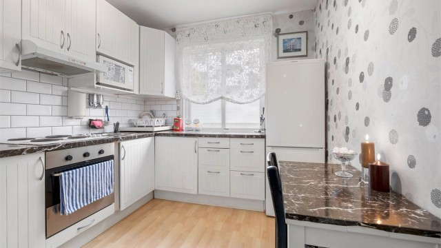 Lyst og pent kjøkken med plass til spiseplass.