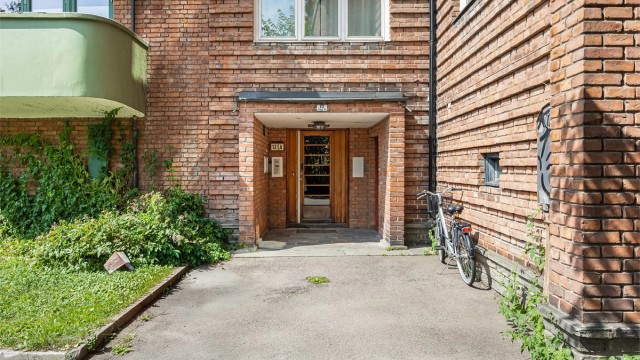 Karakteristisk bygård fra 1931 med teglsteinsfasade. Inngang til felles trapperom.