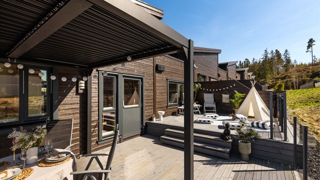 Pergolaen skaper en lun og definert sone for spiseplassen utendørs.