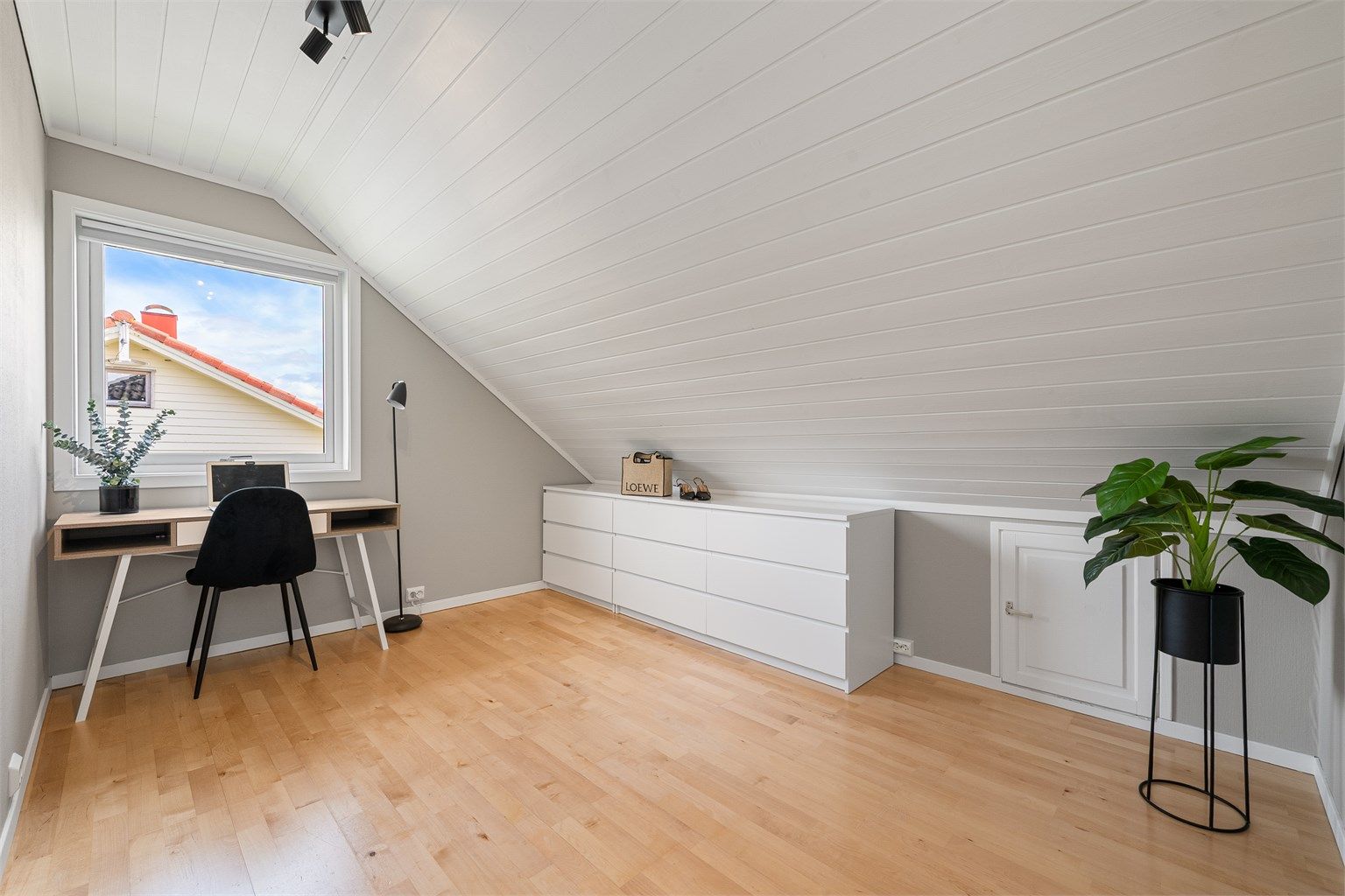 Soverom med parkett på gulv og malt panel i taket