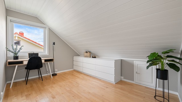 Soverom med parkett på gulv og malt panel i taket