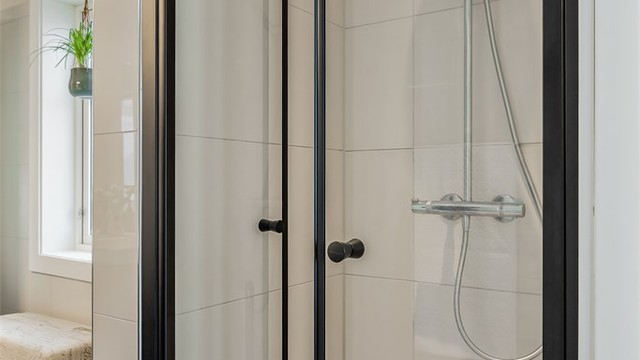 Dusjnisje med nedsenket gulv og innfellbare glassdører.