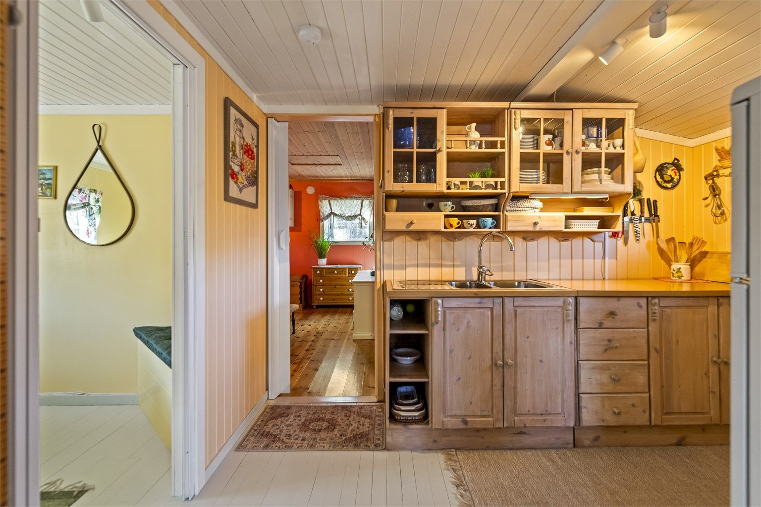 Kjøkkenet har malte heltre gulvbord og panel på vegger og i himling.