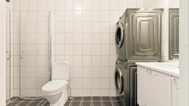 Badet i hovedetasjen har flislagt gulv med gulvvarme og praktisk opplegg for vaskesøyle.