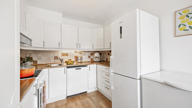 Kjøkkeninnredning fra byggeåret med profilerte fronter og laminert benkeplate.