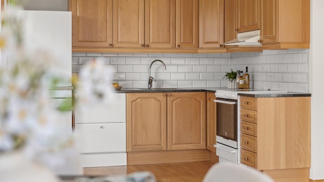 Innredningen har en kombinasjon av slette og profilerte fronter med laminert benkeplate. God skap- og benkeplass.