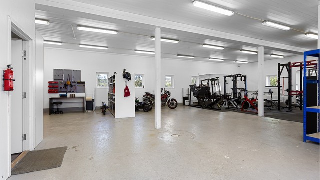 Romslige arealer i låven tilrettelagt for treningsrom, hobby og verksted.