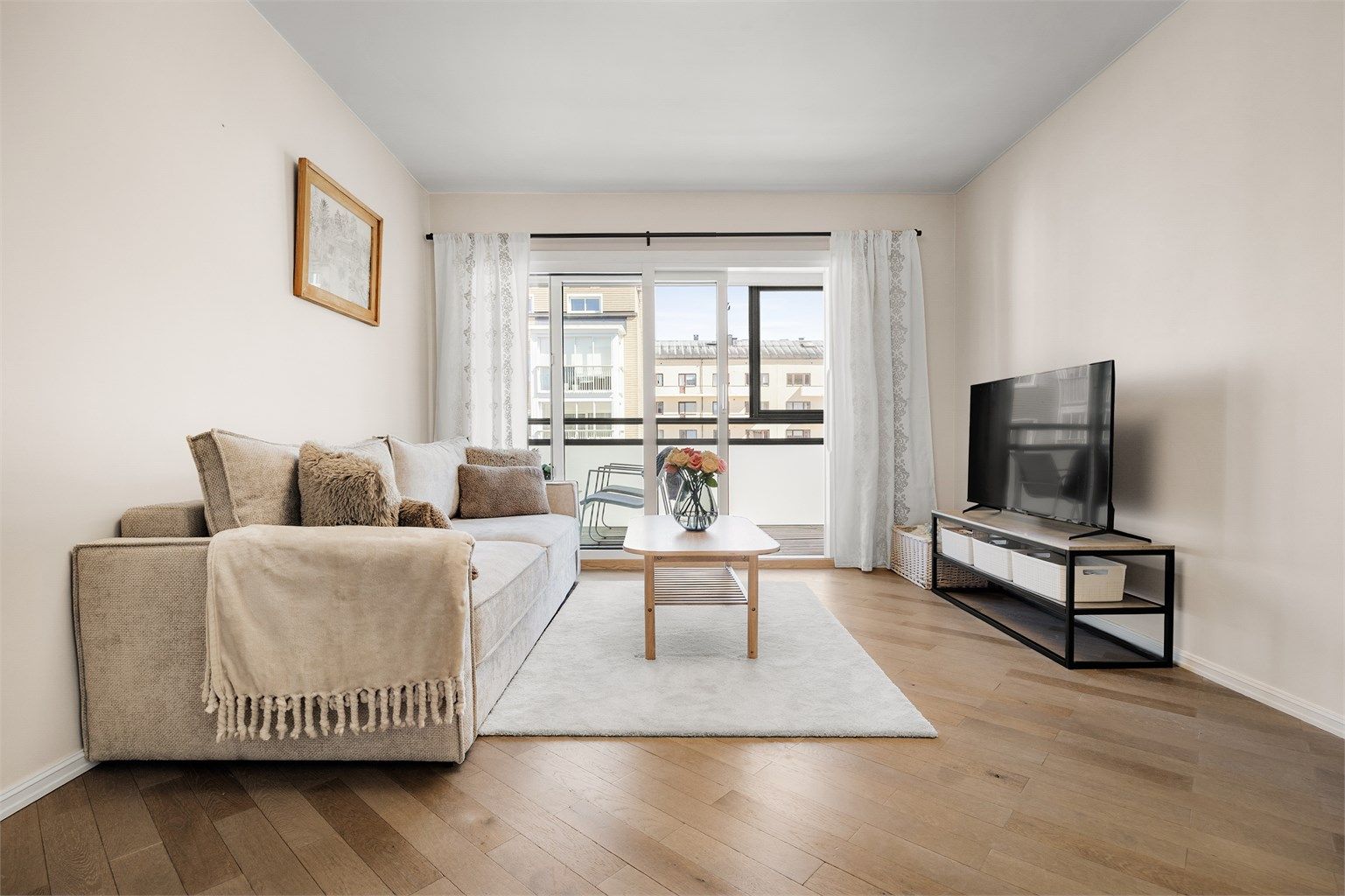 Lys stue med plass til sofagruppe og tv-møblement. 