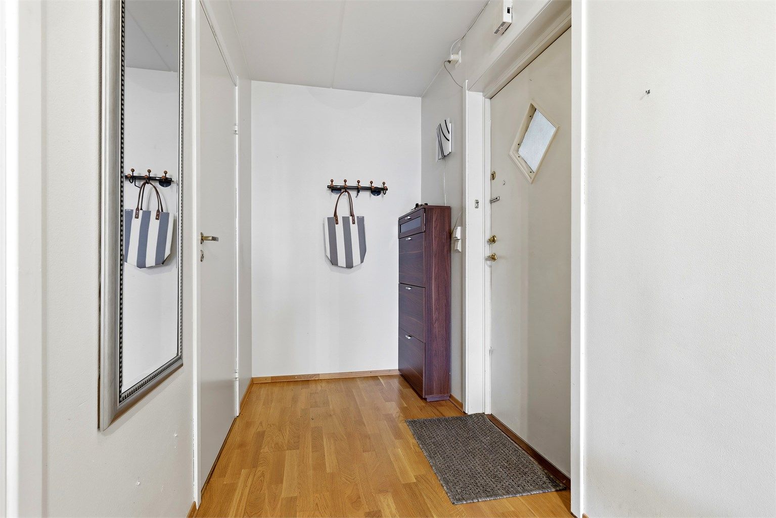 Leilighetens entré/gang har fin plass til oppsetting av garderobeskap eller som her skoskap