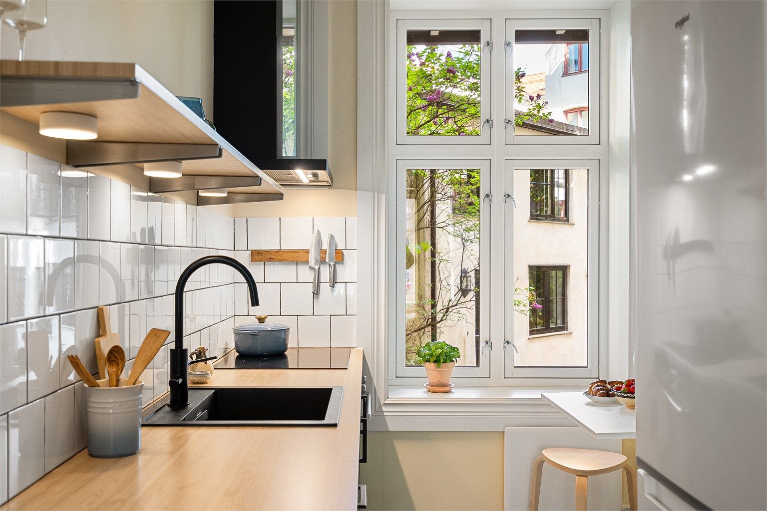 Kjøkkenet vender ut mot hyggelig bakgård og foran vinduet er det et lite utslagsbord - perfekt for frokost eller raske måltider.