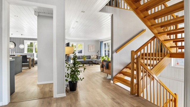 Den lakkerte tretrappen med rekkverk forbinder boligens tre plan.