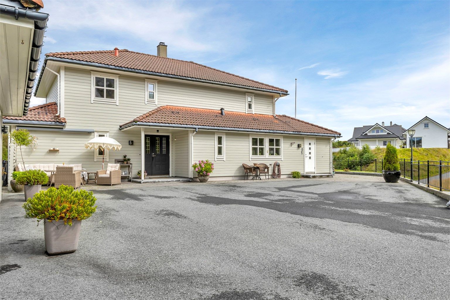 Stor og flat tomt på 1,6 mål med asfaltert tun, belegningsstein, plenareal, diverse beplantning og flere uteplasser. Dobbelgarasje og gode parkeringsmuligheter for flere biler på tunet.