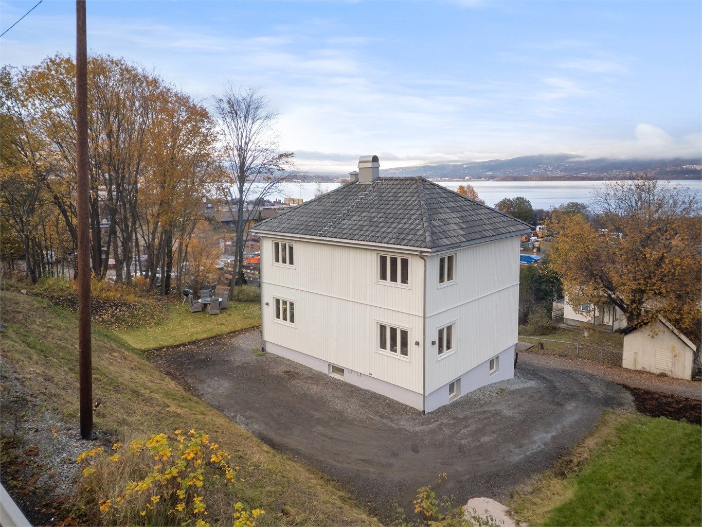 Eiendommen har en romslig tomt med både hage og gruset gårdsplass for parkering.