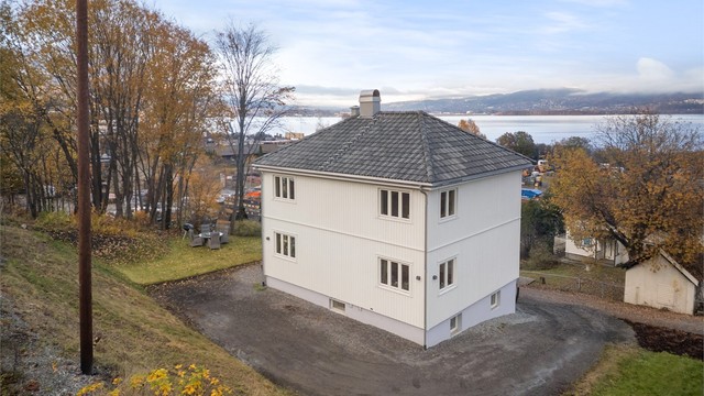 Eiendommen har en romslig tomt med både hage og gruset gårdsplass for parkering.