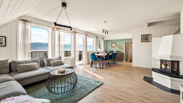 Stuen er et lyst og romslig allrom med plass til både sofagruppe og spisebord. Boligen har både peisovn og varmepumpe.