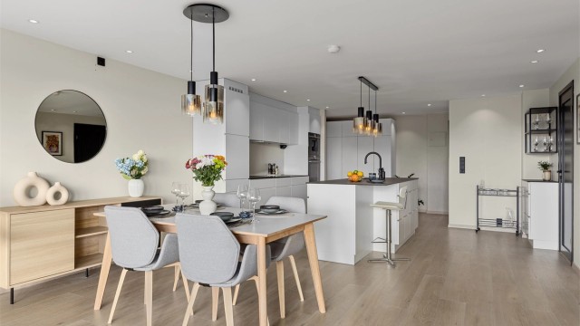 Den åpne stue-/kjøkkenløsningen gjør rommet til et sosialt oppholdsrom, med mye lys og luft