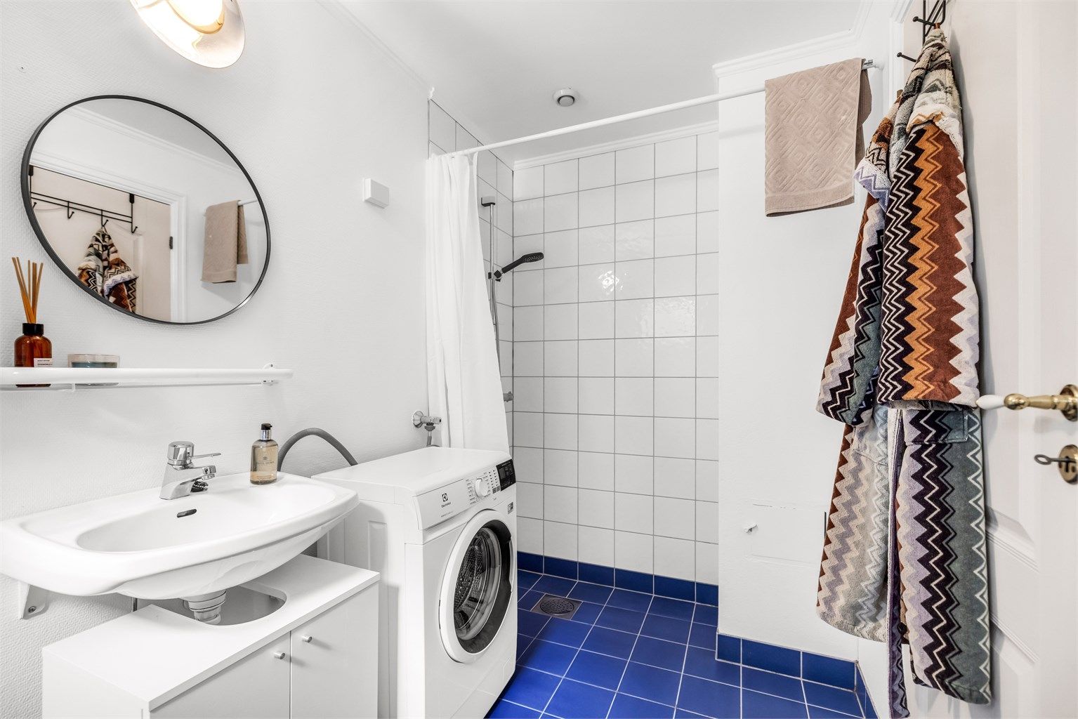 Lyst baderom fra byggeår med flislagt gulv og gulvvarme. 