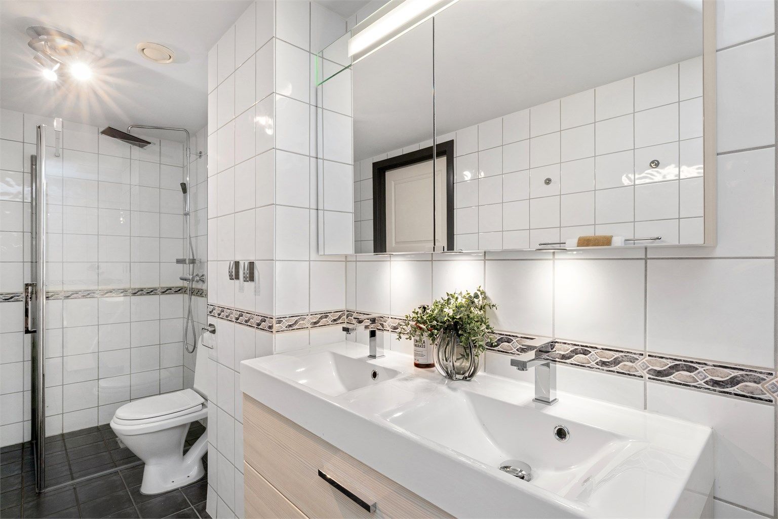 Dobbel servant med svært god lagringsplass i stort servantmøbel med skuffer, i tillegg til dobbelt speilskap med integrert belysning.