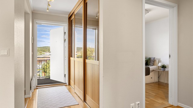 Entré med parkettgulv og god plass til oppbevaring i garderobeskap med skyvedører.