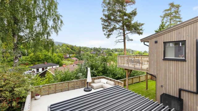 Terrassen leder videre ned til nedre del av eiendommen via en trapp