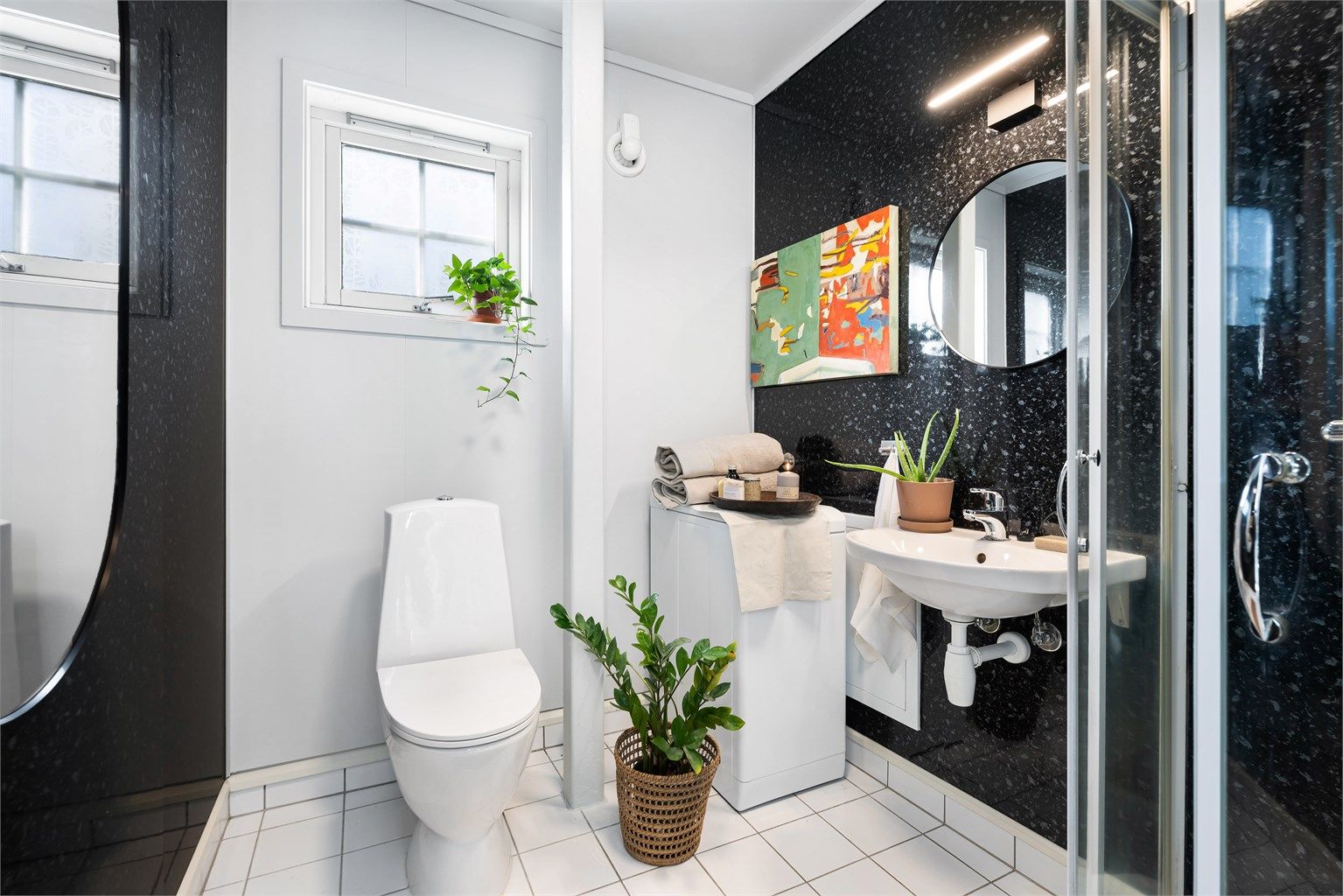 Badet er fra 2004 og har flislagt gulv med gulvvarme og baderomspanel på vegg. Opplegg for vaskemaskin.