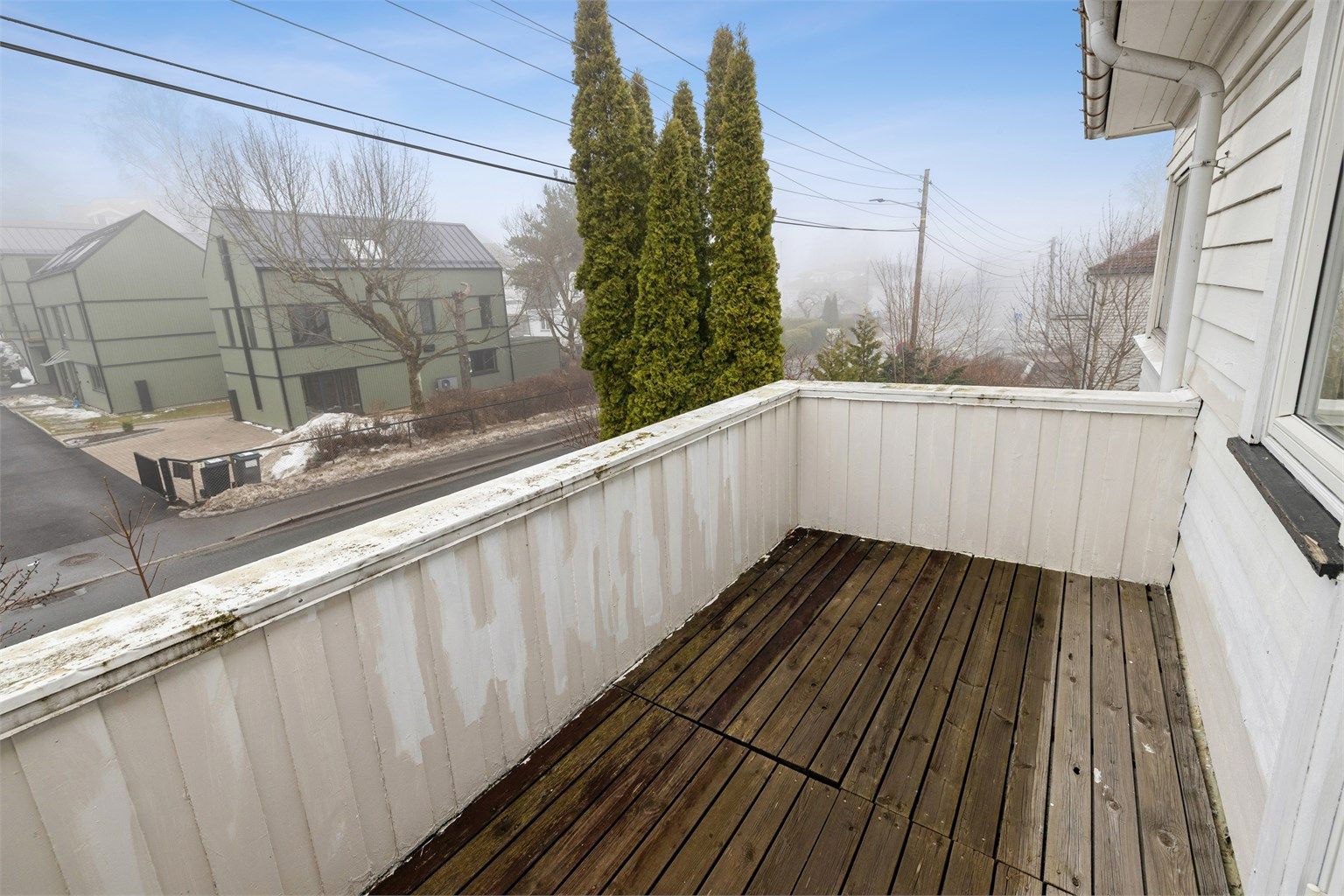 Sydvendt balkong på ca. 7 m² med tremmegulv og plass til en sittegruppe.