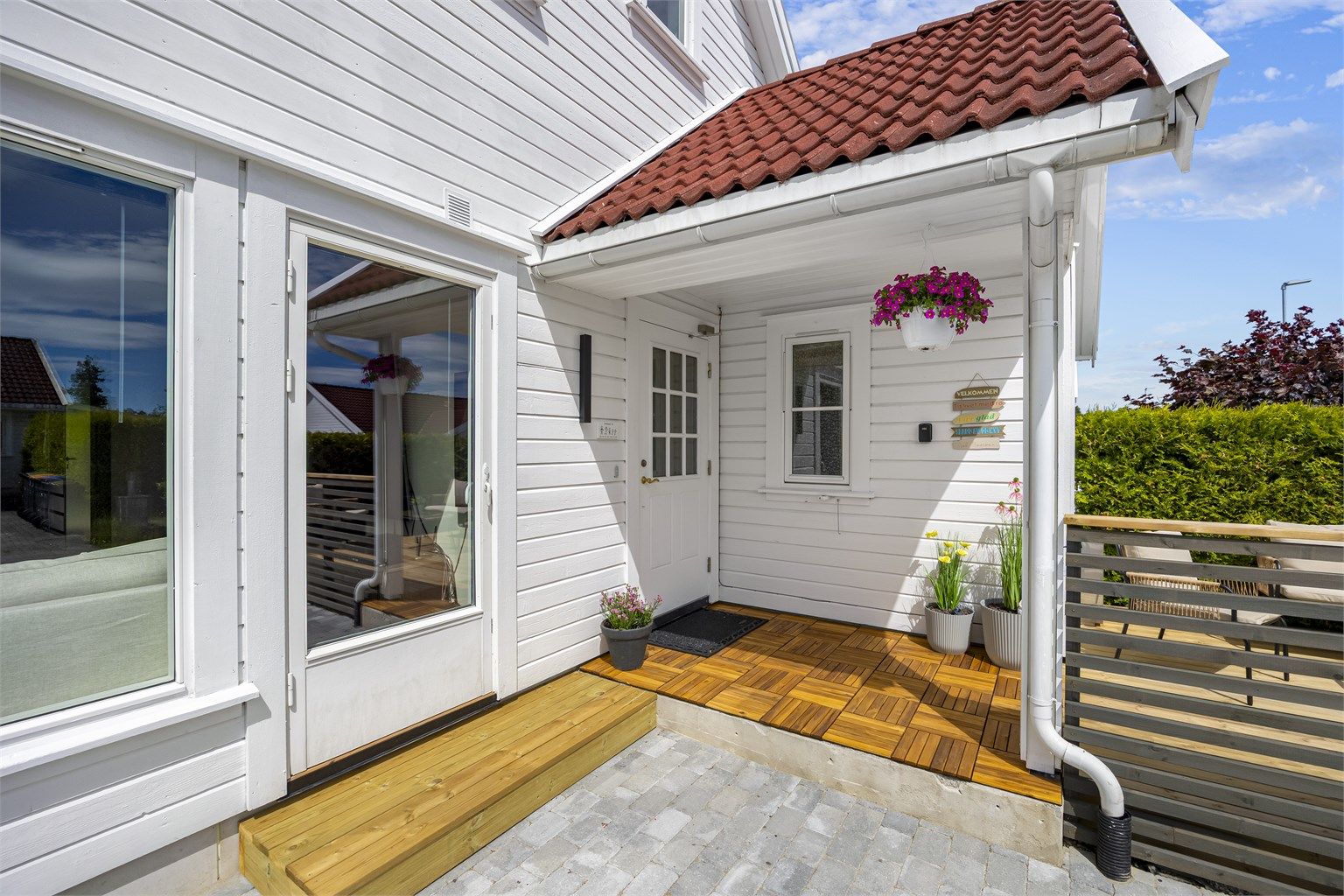 Overbygget inngangsparti med ny platting i behandlet tre.