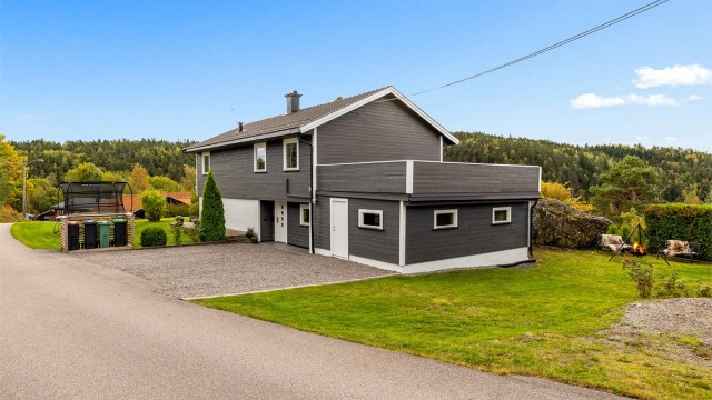 Det velholdte huset ligger nydelig til på en høyde med utsikt og gode solforhold. (Tilbygg med bod og terrasse over er trolig ikke omsøkt)